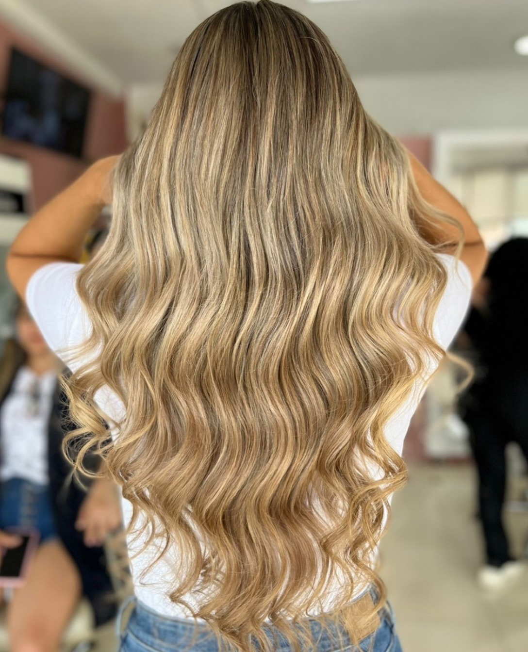 Vista posterior de una melena larga con ondas y mechas rubias